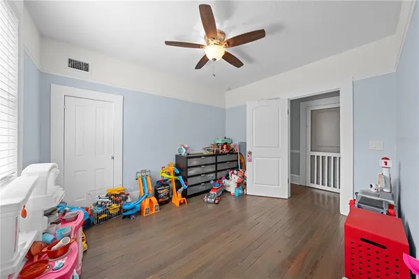 a children room with furniture and wooden floor