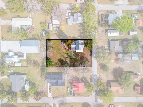 a view of a house with a big yard and large trees