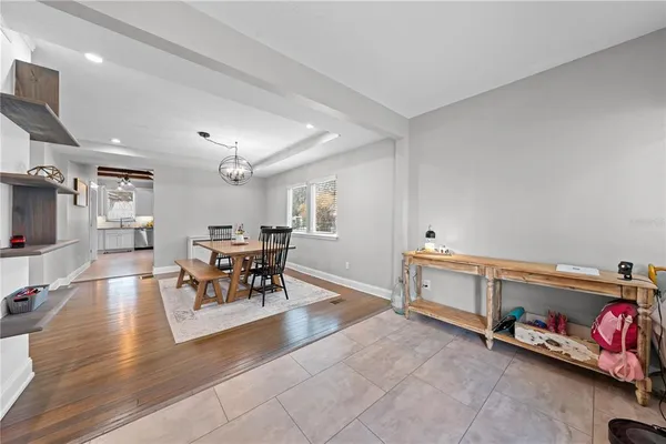 a living room with furniture and a dining table with wooden floor