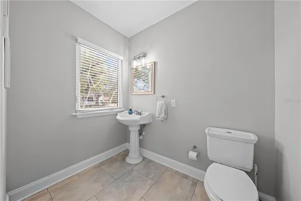 a bathroom with a sink toilet and a window