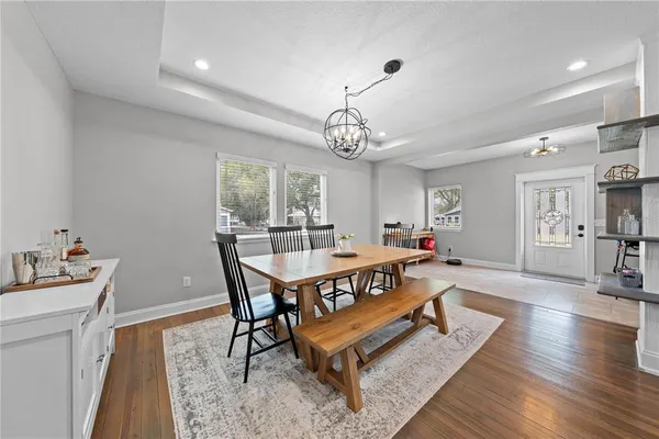 a living room with a dining table and paintings on the wall