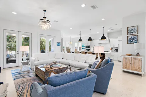 a living room with furniture kitchen view and a large window