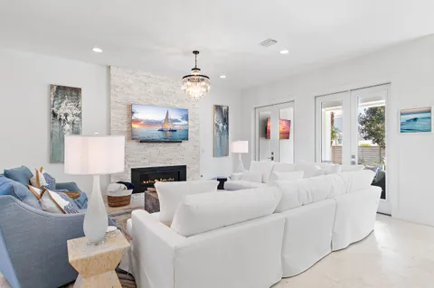 a living room with furniture a fireplace and a chandelier