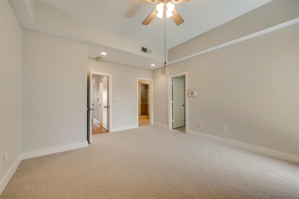 5055 Addison Circle, Unit 407 Addison, TX 75001 - Photo 17 of 22 Another View of Primary Bedroom with Doors to Hall, Ensuite Bath, Large Closet