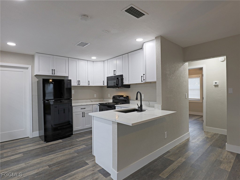 14181 Old Olga Road Fort Myers, FL 33905 - Photo 4 of 13 a kitchen with a sink dishwasher a refrigerator and a stove with wooden floor