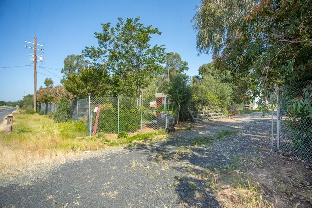 a view of a house with backyard and trees