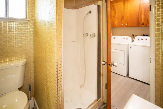 an empty room with wooden floor and a bathroom