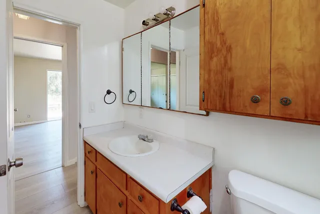 an empty room with wooden floor and a bench