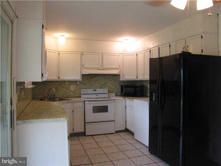18 Tinder Road Levittown, PA 19056 - Photo 3 of 25 a kitchen with a refrigerator and a stove top oven