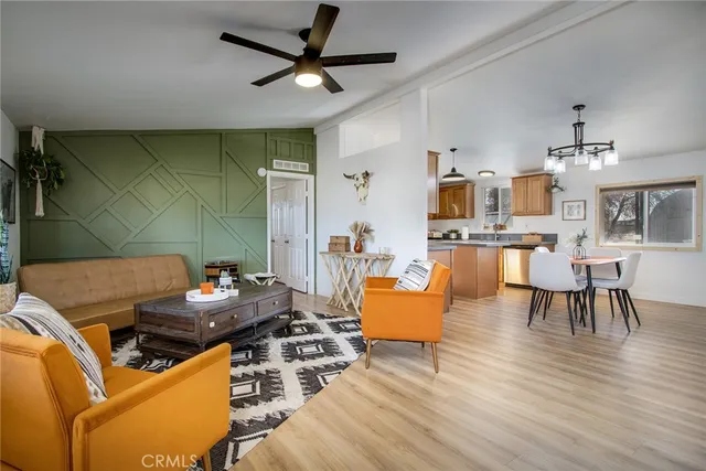 a living room with stainless steel appliances kitchen island granite countertop furniture and a wooden floor