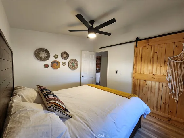 a bedroom with a large bed and a chandelier