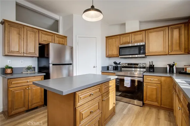 a kitchen with stainless steel appliances a stove refrigerator sink and microwave