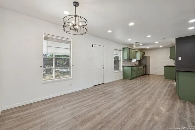 a view of empty room with wooden floor and windows