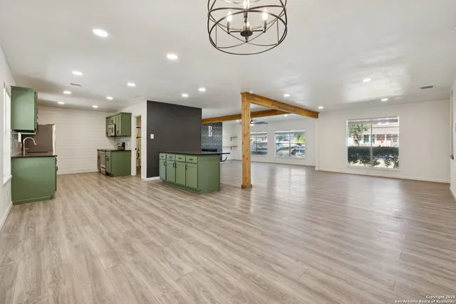 an empty room with a wooden floor and windows