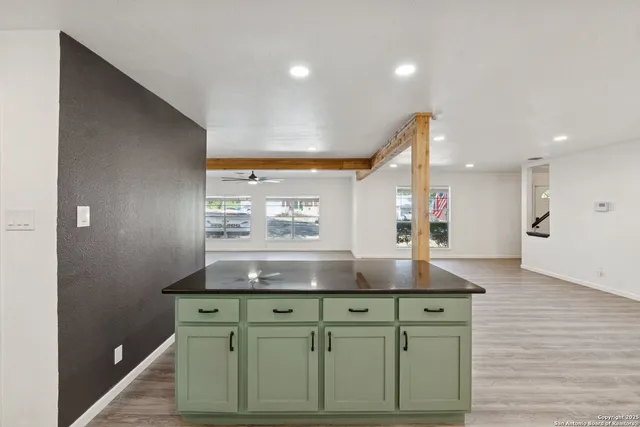 a view of kitchen with kitchen island a counter top space a sink and cabinets