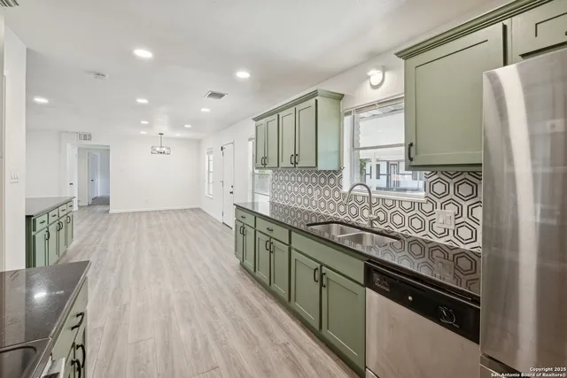 a large kitchen with stainless steel appliances granite countertop a lot of counter space and a sink