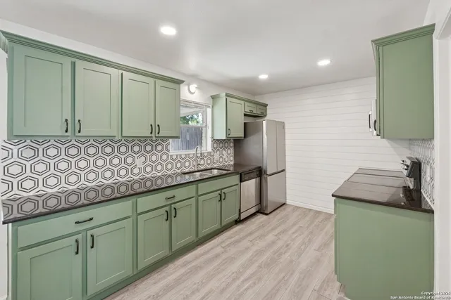 a bathroom with a granite countertop sink and a large mirror