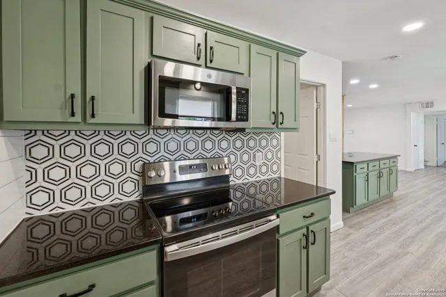 a kitchen with stainless steel appliances granite countertop a sink stove and microwave