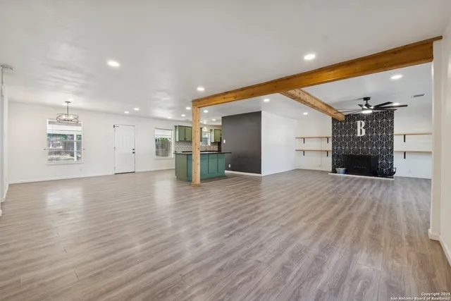 a view of empty room with wooden floor and fireplace
