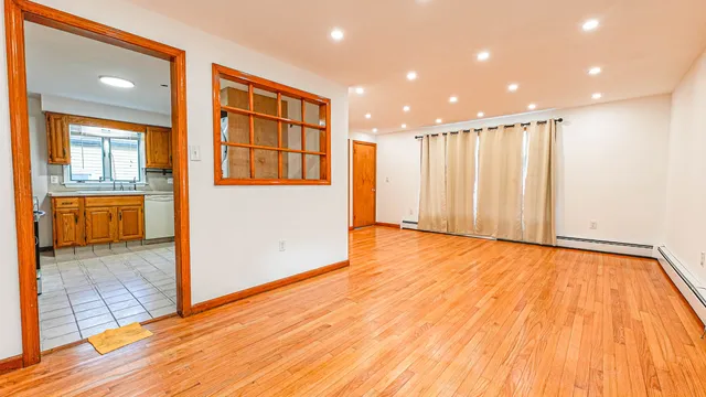 a view of a hallway with wooden floor and cabinet