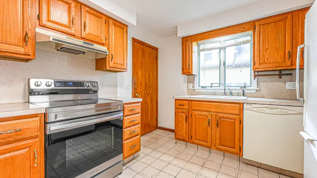 a kitchen with stainless steel appliances granite countertop a stove a sink and a refrigerator