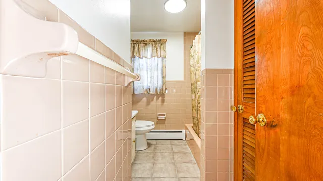 a bathroom with a toilet and a shower