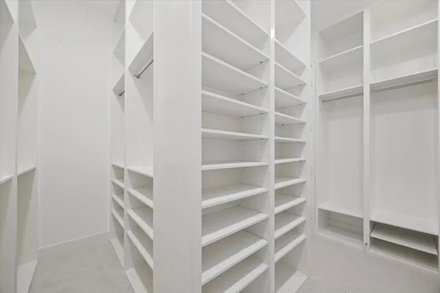 a view of walk in closet with empty racks