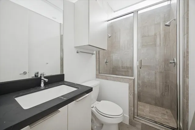 a bathroom with a sink a toilet and shower