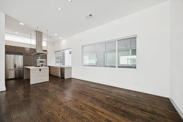 a view of kitchen with stainless steel appliances kitchen island wooden floor and window