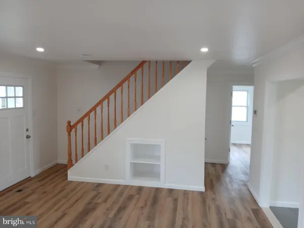 a kitchen with kitchen island a sink wooden floor and a large window