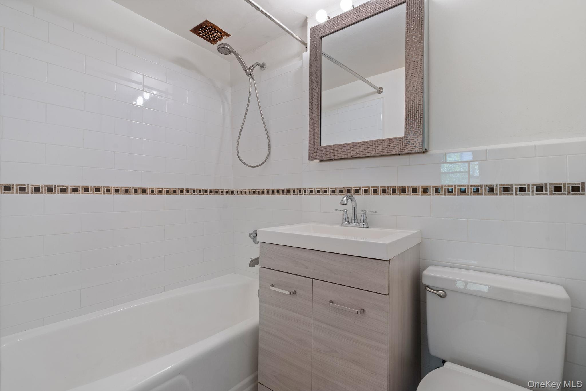 61-15 97th Street, Unit 2D Queens, NY 11374 - Photo 7 of 11 a bathroom with a sink a toilet and a bathtub