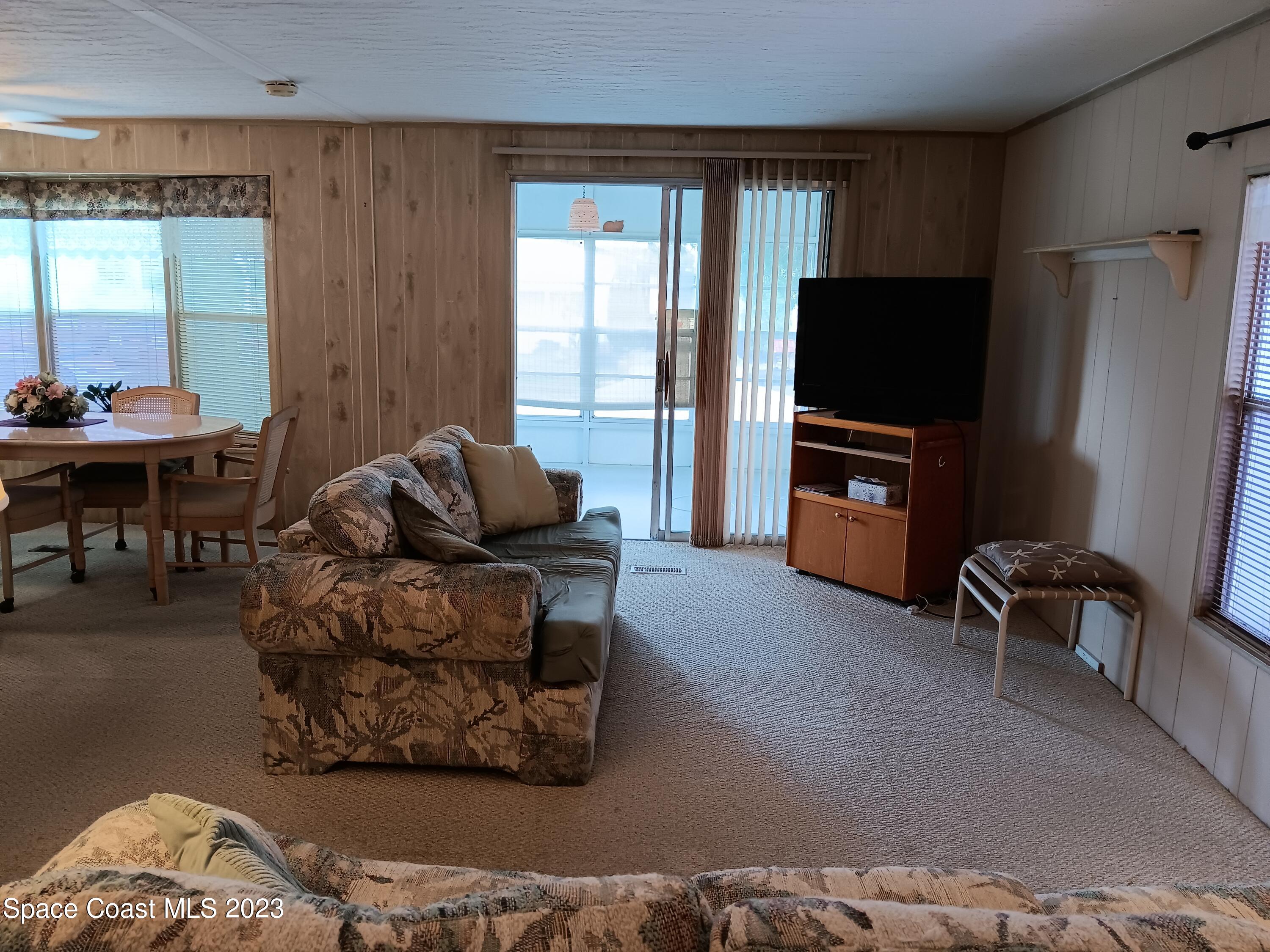 511 Puffin Drive Barefoot Bay, FL 32976 - Photo 14 of 25 a living room with furniture and a flat screen tv