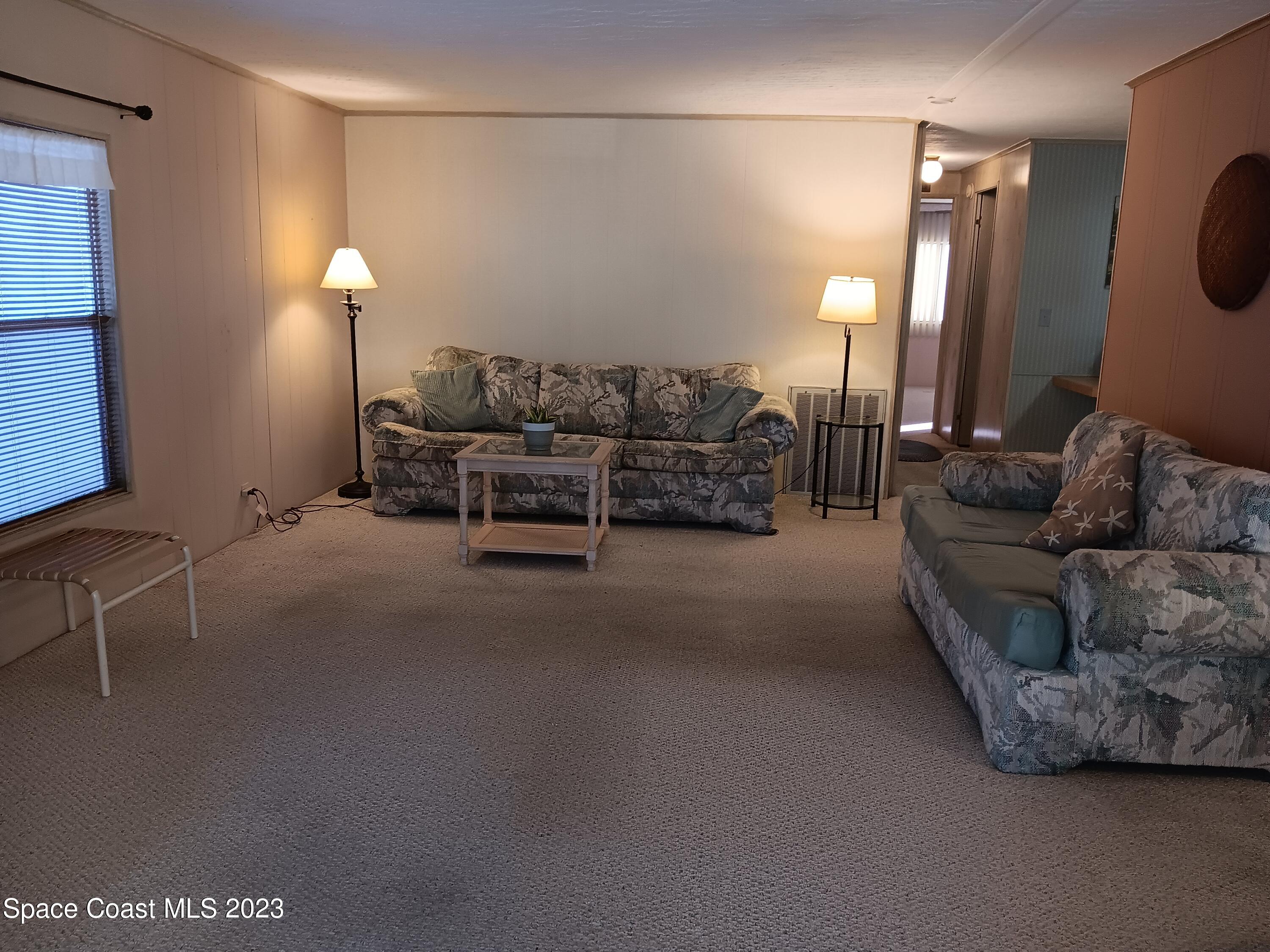 511 Puffin Drive Barefoot Bay, FL 32976 - Photo 16 of 25 a living room with furniture and a lamp