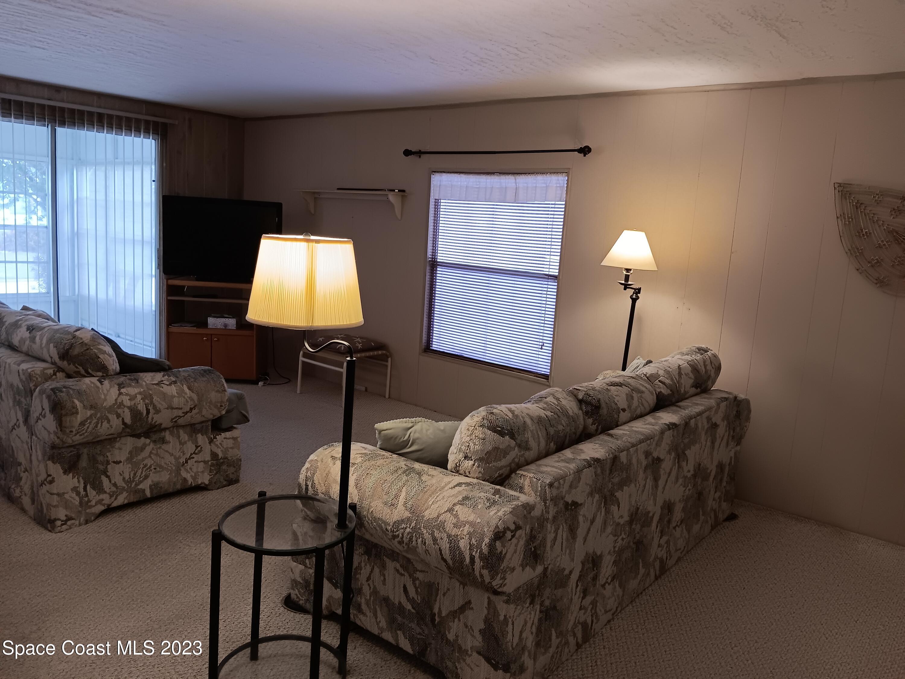 511 Puffin Drive Barefoot Bay, FL 32976 - Photo 17 of 25 a living room with furniture and a lamp