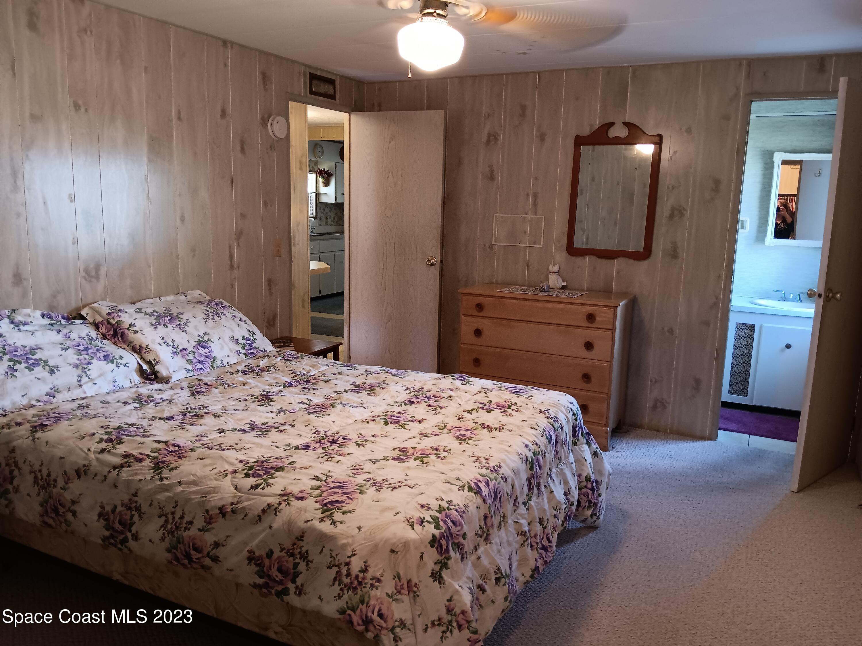 511 Puffin Drive Barefoot Bay, FL 32976 - Photo 18 of 25 a bedroom with a bed and a mirror