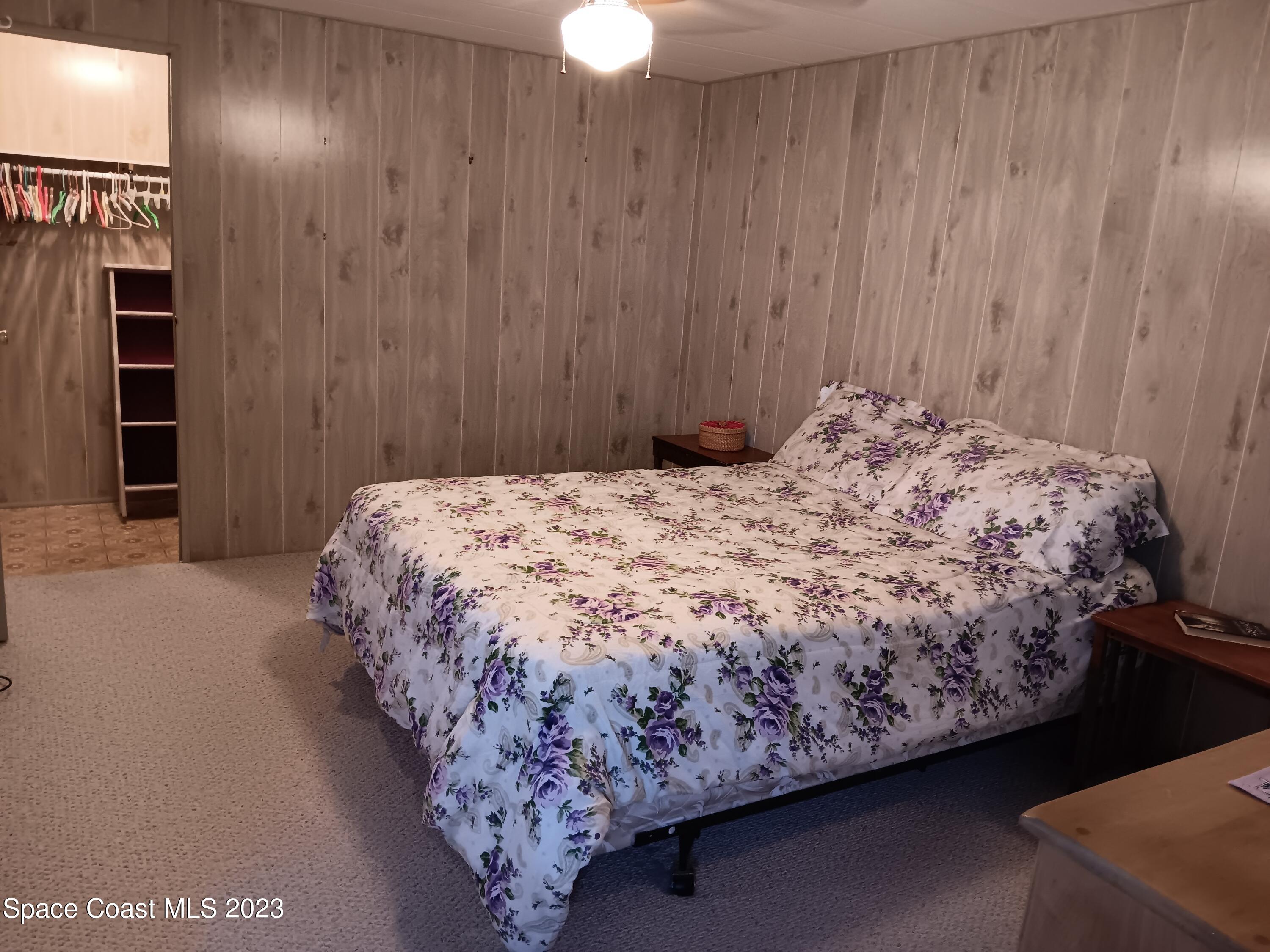 511 Puffin Drive Barefoot Bay, FL 32976 - Photo 20 of 25 a bedroom with a bed and a chandelier