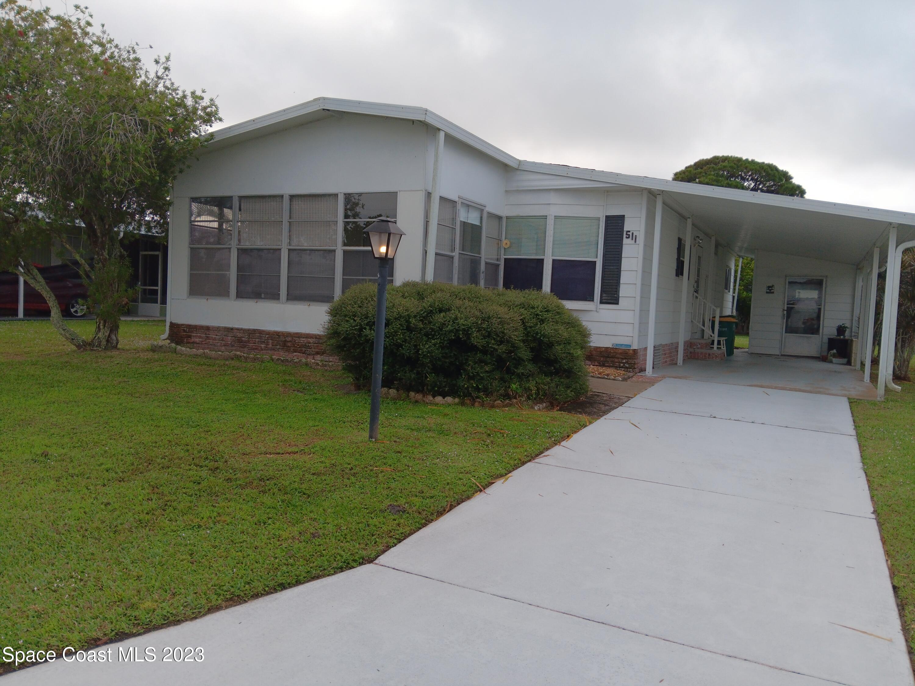511 Puffin Drive Barefoot Bay, FL 32976 - Photo 2 of 25 a front view of a house with a yard and porch