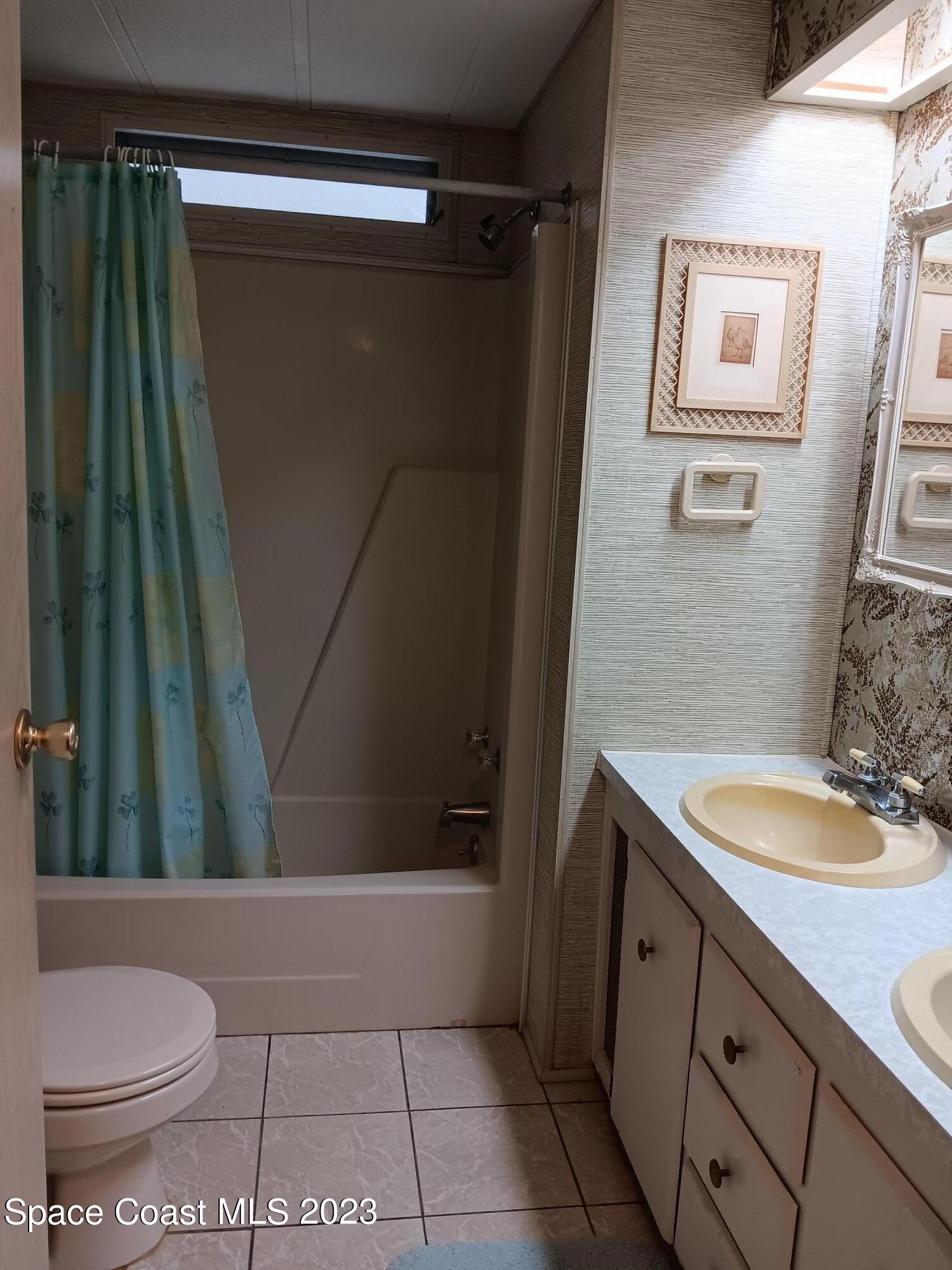 511 Puffin Drive Barefoot Bay, FL 32976 - Photo 25 of 25 a bathroom with a granite countertop sink toilet and shower