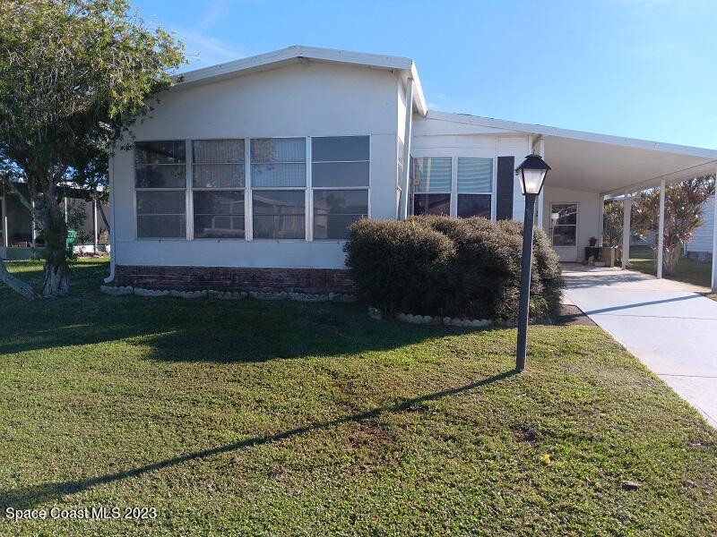 511 Puffin Drive Barefoot Bay, FL 32976 - Photo 3 of 25 a front view of a house with garden
