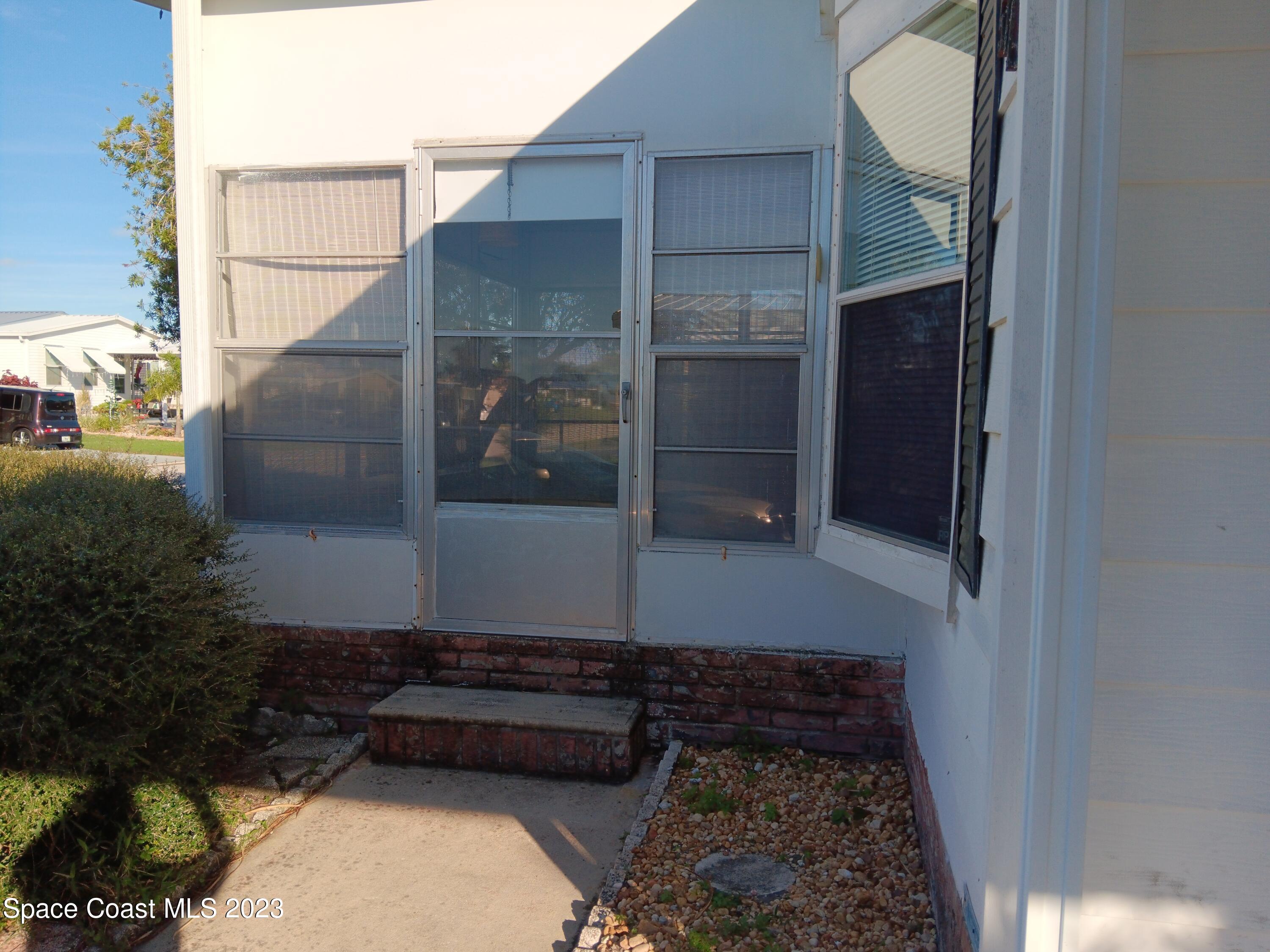 511 Puffin Drive Barefoot Bay, FL 32976 - Photo 4 of 25 a front view of a house with a yard