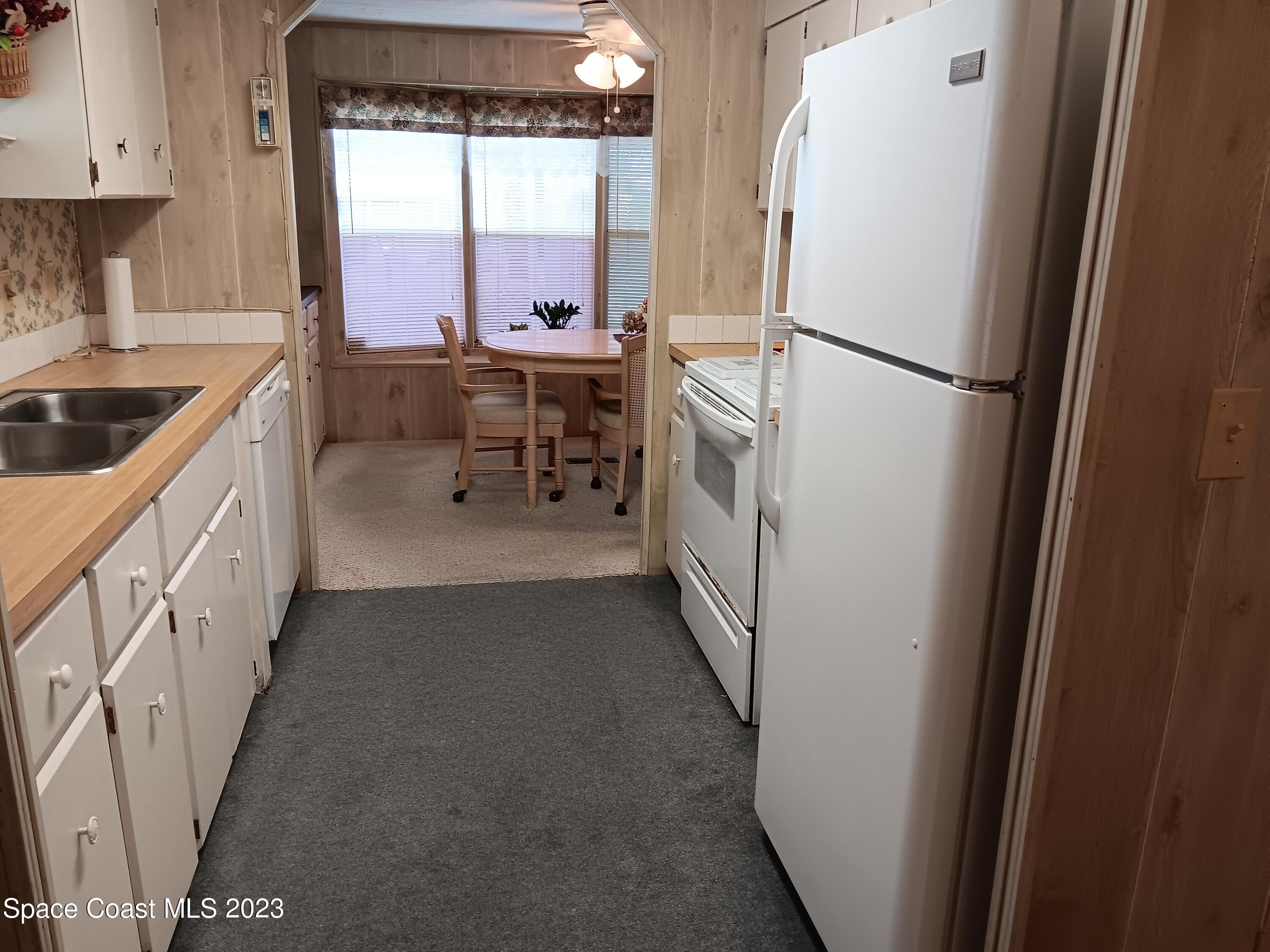 511 Puffin Drive Barefoot Bay, FL 32976 - Photo 8 of 25 a kitchen with sink refrigerator and window