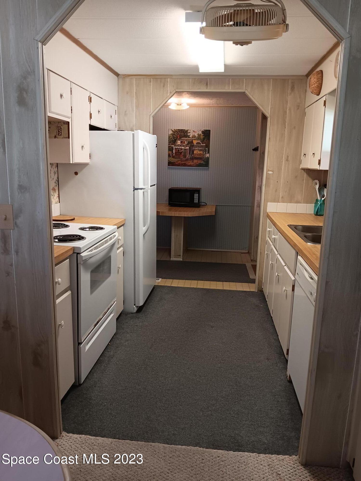 511 Puffin Drive Barefoot Bay, FL 32976 - Photo 9 of 25 a kitchen with a refrigerator sink and stove