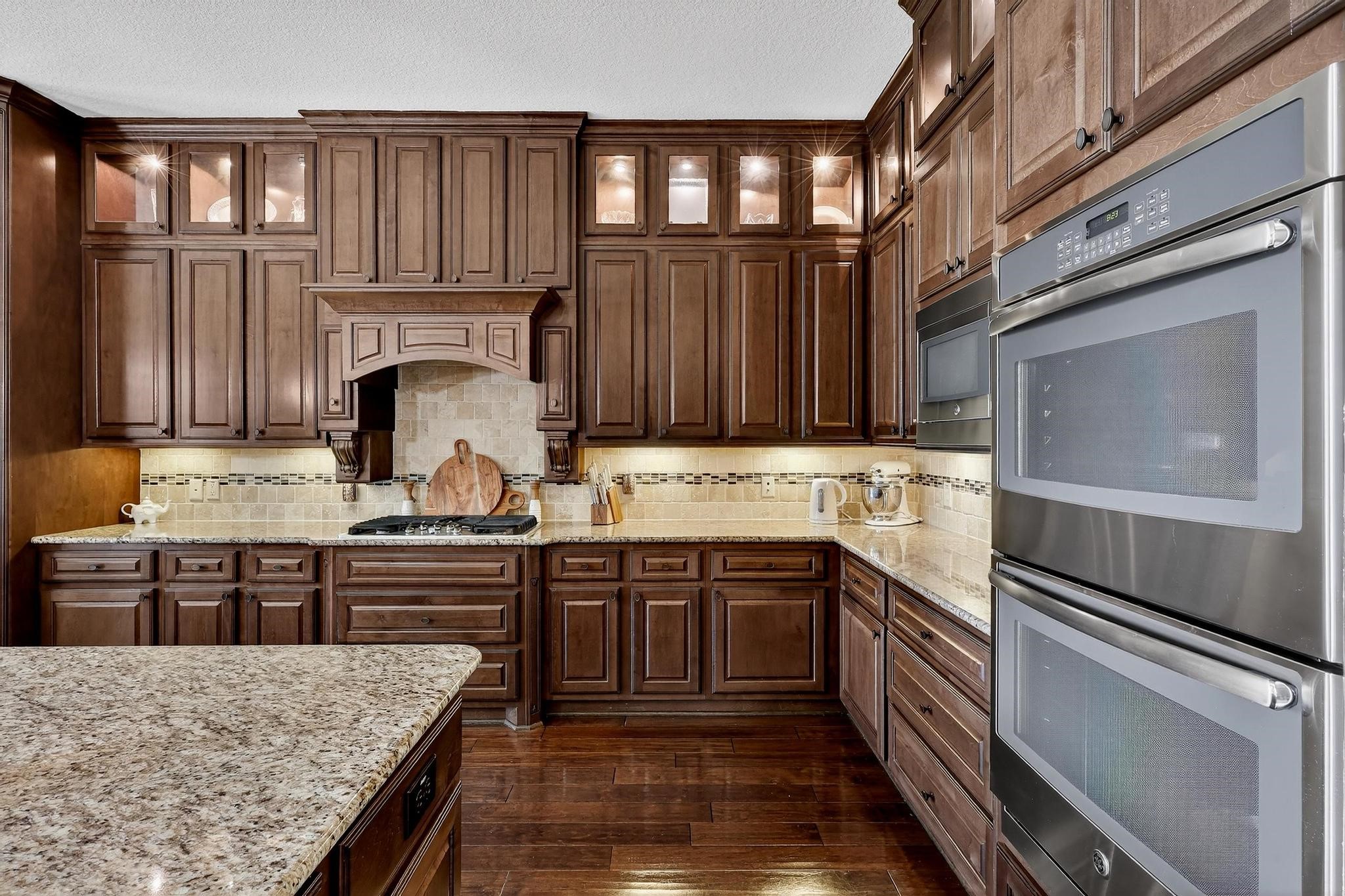 25803 Heritage Maple Drive Spring, TX 77389 - Photo 15 of 46 a kitchen with kitchen island granite countertop wooden cabinets a sink and dishwasher