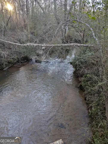 a view of a dry yard with wooden fence