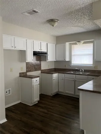 a kitchen with granite countertop white cabinets and white appliances