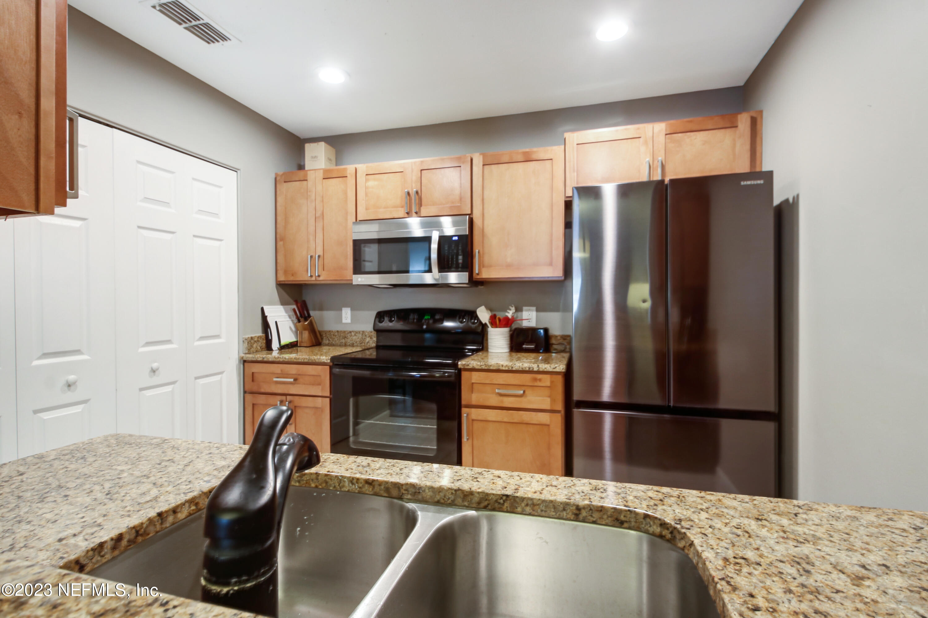 3801 Crown Point Road, Unit 3012 Jacksonville, FL 32257 - Photo 14 of 30 a kitchen with granite countertop a refrigerator stove and sink