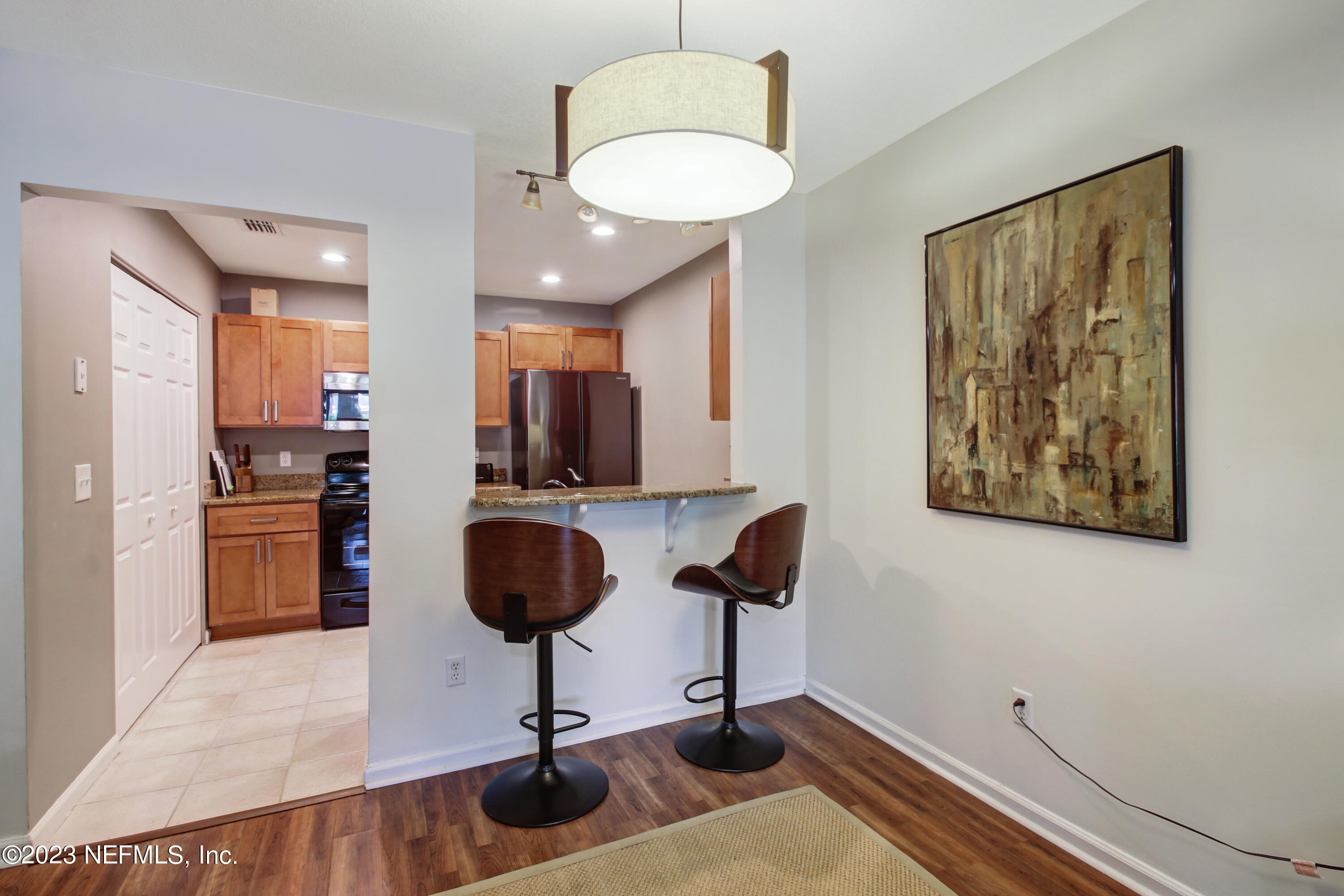3801 Crown Point Road, Unit 3012 Jacksonville, FL 32257 - Photo 10 of 30 a view of a kitchen with kitchen island granite countertop wooden floor and a refrigerator