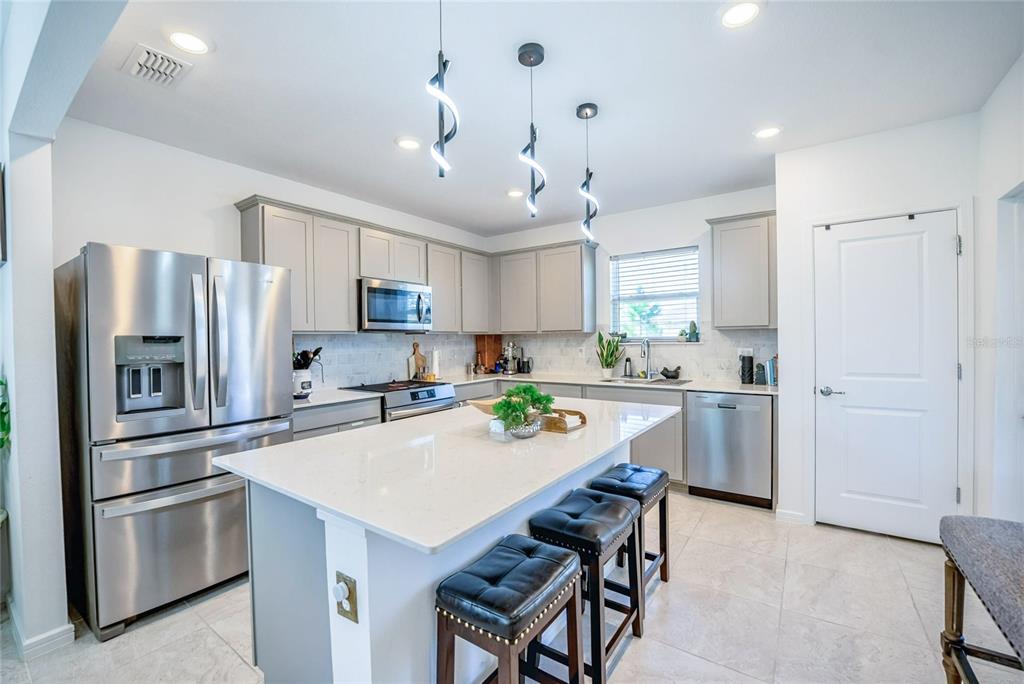 8413 Southwest 54th Street Ocala, FL 34481 - Photo 18 of 57 a kitchen with stainless steel appliances a refrigerator a stove a sink a dining table and chairs