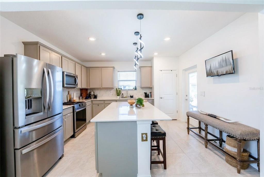8413 Southwest 54th Street Ocala, FL 34481 - Photo 19 of 57 a large kitchen with stainless steel appliances kitchen island granite countertop a refrigerator and a stove top oven
