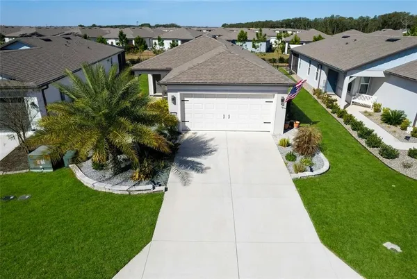 a aerial view of a house with a yard and potted plants